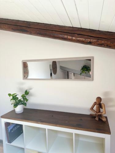 a mirror above a shelf in a room at La Casetta del Centro Luminoso loft con terrazzo e giardino in Biella
