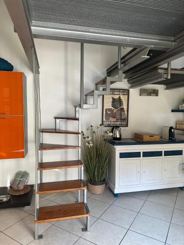 a kitchen with a spiral staircase in a room at La Casetta del Centro Luminoso loft con terrazzo e giardino in Biella