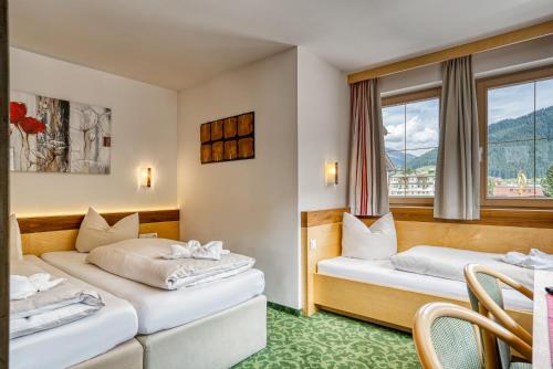 Postel nebo postele na pokoji v ubytování Hotel Sonnenhof Gerlos Centrum
