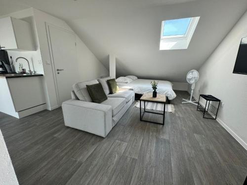 un salon avec un canapé et un lit dans l'établissement Studio eucalyptus charmant élégant et fonctionnel Centre ville, à Mulhouse