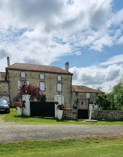 a large brick house with a fence in front of it at La Petite Locherie in Oradour-Saint-Genest