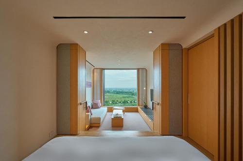 a bedroom with a bed and a large window at Hotel Royal Chiao Hsi in Jiaoxi