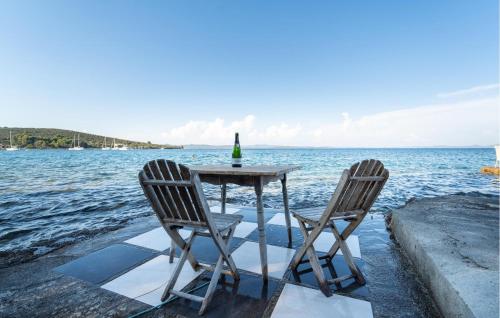 a table with two chairs sitting next to the water at 5 Bedroom Stunning Home In Zman in Žman