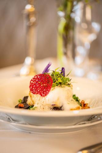 a plate of food with a strawberry on top at MICHELS Wellness- & Wohlfühlhotel in Schalkenmehren