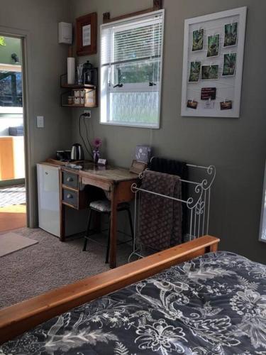 a bedroom with a desk and a bed and a desk and chair at Fantail at Bluestone Retreat in Leeston