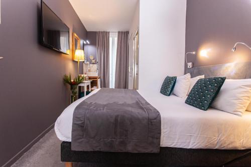 Ένα ή περισσότερα κρεβάτια σε δωμάτιο στο Hôtel Churchill Bordeaux Centre