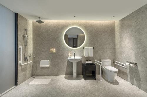 a bathroom with a sink and a toilet and a mirror at Crowne Plaza Lanzhou New Area by IHG in Lanzhou