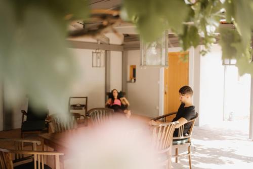 a young man sitting at a table in a room at Hotel Raffel in Jennersdorf