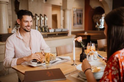 a man and woman sitting at a table in a restaurant at Hotel Raffel in Jennersdorf