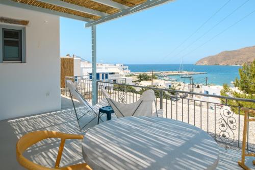 a balcony with a table and chairs and the ocean at Amorgos Elegant Houses, 6 Villas in Amorgos