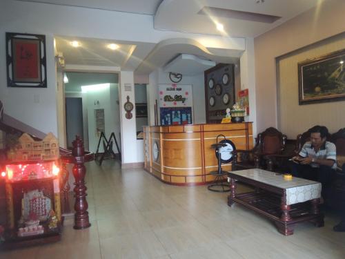 a man sitting on a couch in a living room at Phuc Hung Hotel in Rach Gia