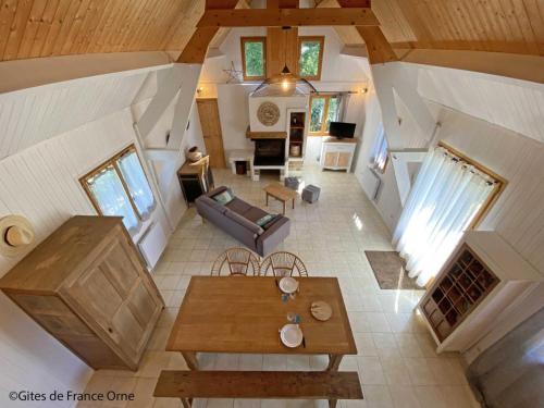 une vue aérienne d'un salon avec un canapé et une table dans l'établissement Chalet tout confort en lisière de forêt avec cheminée, terrasse et accès direct à un étang de pêche - FR-1-497-213, à Chaumont
