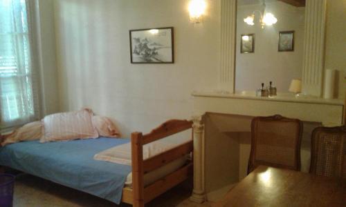 a small bedroom with a bed and a desk at LE SULTAN DU THERON 1er Etage in Le Puy-en-Velay