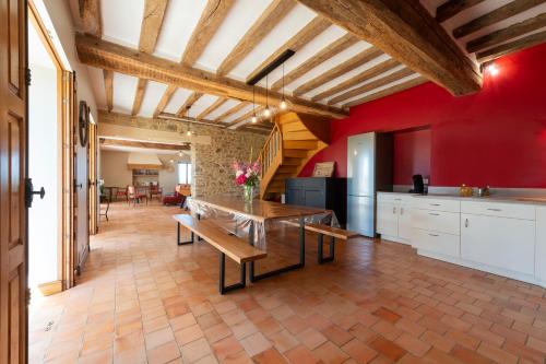Il comprend une cuisine dotée de murs rouges et d'un plafond en bois. dans l'établissement La Villa au Grand Chêne - Charmante maison pour 10p, à Challain-la-Potherie