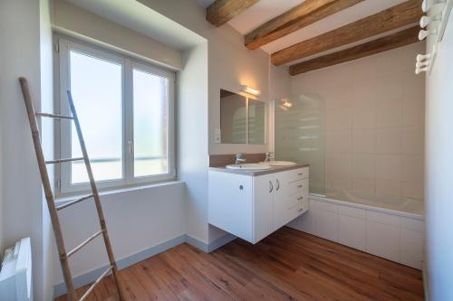 a bathroom with a sink and a tub and a window at La Villa au Grand Chêne - Charmante maison pour 10p in Challain-la-Potherie