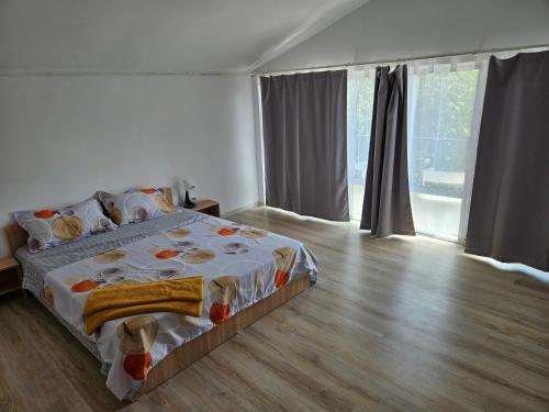 a bedroom with a large bed and a wooden floor at Casa Cristian in Limanu