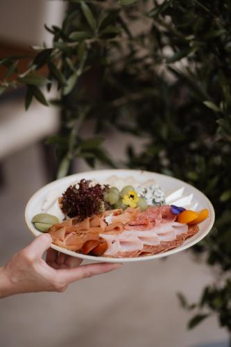 a person is holding a plate of food at Hotel Raffel in Jennersdorf