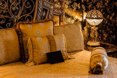 a bed with pillows and a table with a lamp at Castello Brancaccio in San Gregorio da Sassola