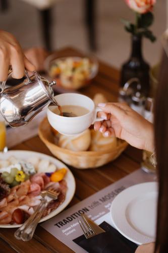a person is holding a cup of tea on a table at Hotel Raffel in Jennersdorf