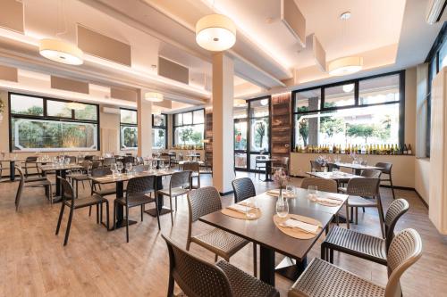 Un restaurante con mesas, sillas y ventanas. en Hotel Stella Del Mare, en Chiavari