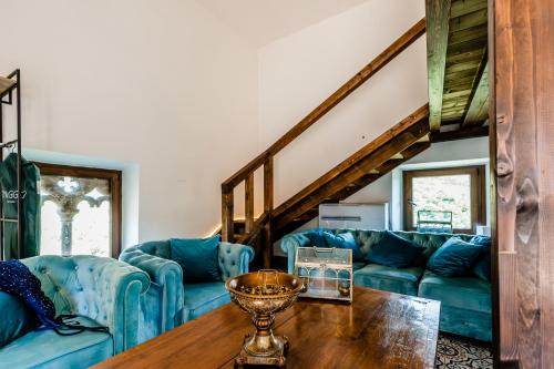 a living room with blue couches and a wooden table at Castello Brancaccio in San Gregorio da Sassola