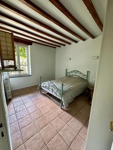 une chambre avec un lit dans une pièce dans l'établissement Longère typique perche, à Fontaine-Raoul