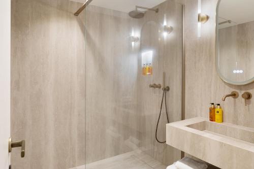 une salle de bain avec douche et lavabo dans l'établissement Pick A Flat's Apartments with Services in Opéra, à Paris