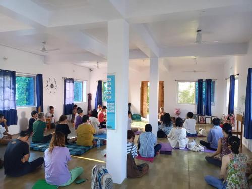 a group of people sitting in a yoga class at Senamura Yoga Ashram Guesthouse in Bodh Gaya