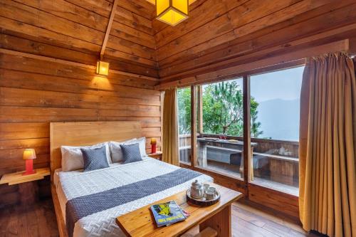 a bedroom with a bed and a large window at Alaya Stays Duplex Cottage with Tree House - Suro Woodcrest Chalet in Shogi