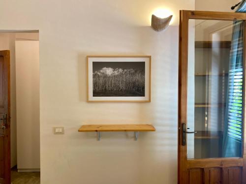 a wooden shelf on a wall next to a door at Stagnone Area Zero in Birgi Vecchi