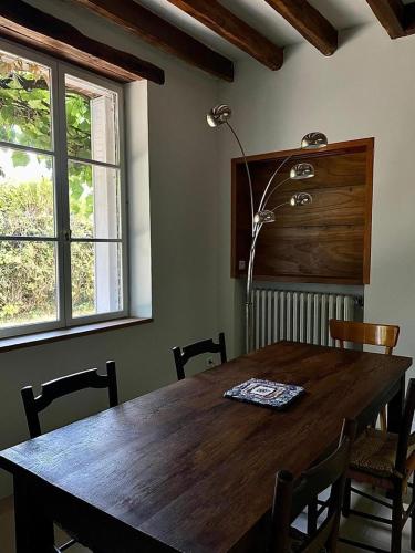 une table à manger avec des chaises et une lampe dans l'établissement Longère typique perche, à Fontaine-Raoul