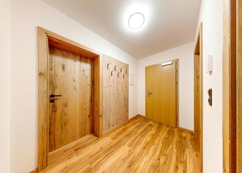a hallway with wooden doors and wooden floors at Haus Moritz in Oetz
