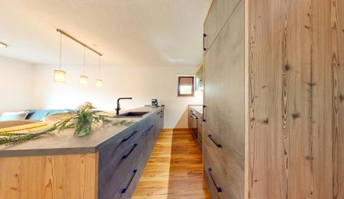 a kitchen with a sink and a large wooden wall at Haus Moritz in Oetz