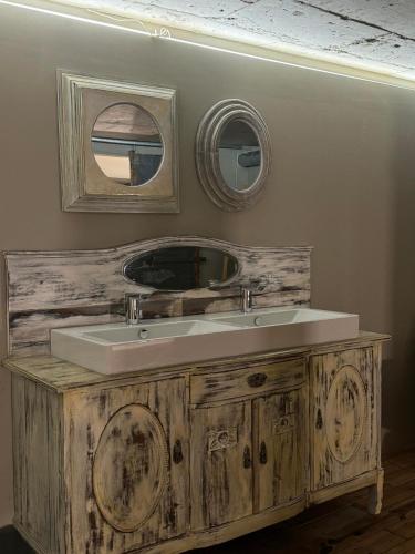 a bathroom with a sink and two mirrors on the wall at Swed Cab Embassy HoStel in Varna City