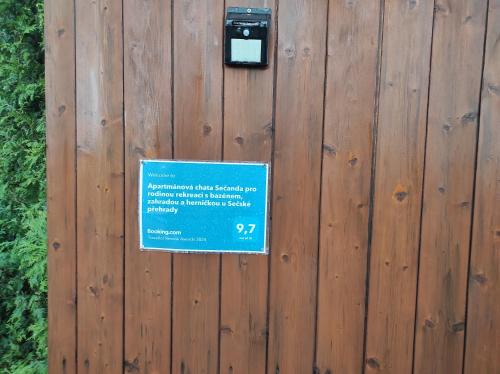 a sign on a wooden fence with a sign on it at Apartmánová chata Sečanda s bazénem, u Sečské přehrady in Seč