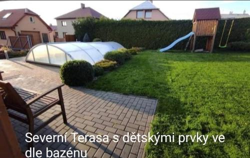 a backyard with a playground with a slide at Apartmánová chata Sečanda s bazénem, u Sečské přehrady in Seč