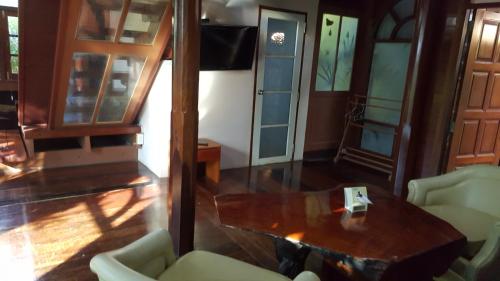 a living room with a table and chairs at Ruean Mai Chai Khlong in Amphawa