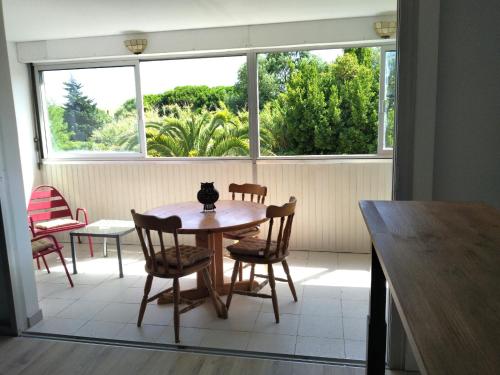 een eetkamer met een tafel en stoelen en een raam bij T2 MARINE Le LAVANDOU in Le Lavandou