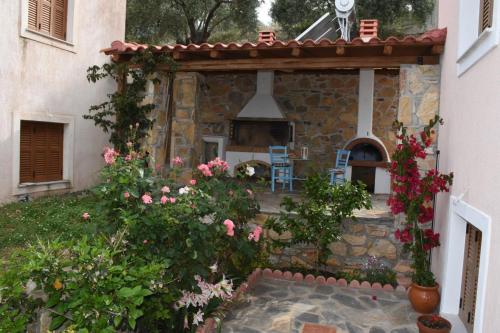 a garden with a stone fireplace and flowers at Goddesses Villa 1 in Nies in Soúrpi