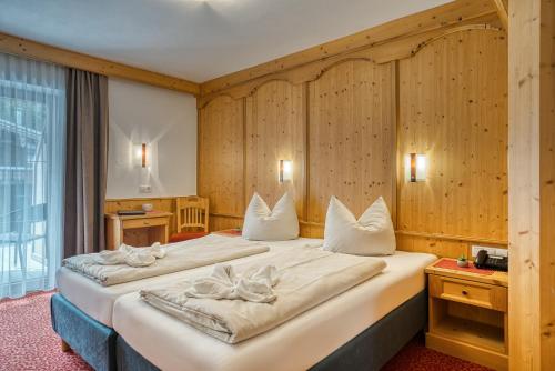 Postel nebo postele na pokoji v ubytování Hotel Sonnenhof Gerlos Centrum