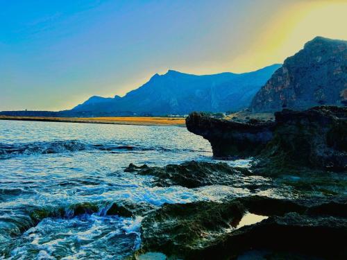 un arcobaleno sopra un corpo d'acqua con rocce di MarGio apartments a San Vito lo Capo