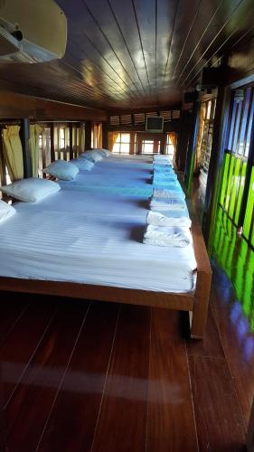 a group of four beds in a room at Ruean Mai Chai Khlong in Amphawa