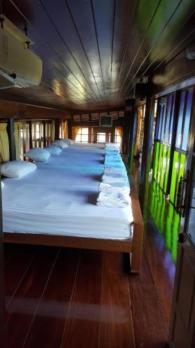 a group of beds lined up in a room at Ruean Mai Chai Khlong in Amphawa