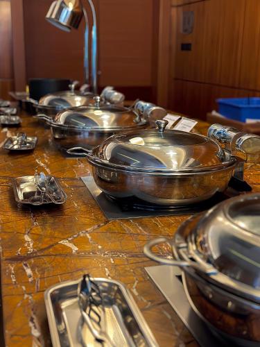 a group of copper pots and pans on a counter at The Sandalwood Beijing Marriott Executive Apartments in Beijing