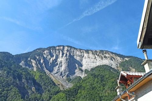 Elle offre une vue sur une montagne bordée d'arbres. dans l'établissement Appartement t2 Bourg d'Oisans, au Bourg-dʼOisans