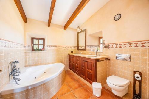a bathroom with a tub and a toilet and a sink at Mirabo ramonet in Caʼs Concos
