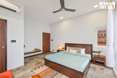 a bedroom with a bed and a ceiling fan at StayVista at The Ganga House - Holy River Varanasi in Varanasi