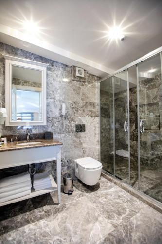 a bathroom with a shower and a toilet and a sink at Opatija Hotel in Istanbul