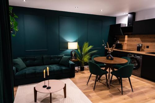 a living room with a green couch and a table at L'Élégant, appartement au cœur de la ville in Saumur