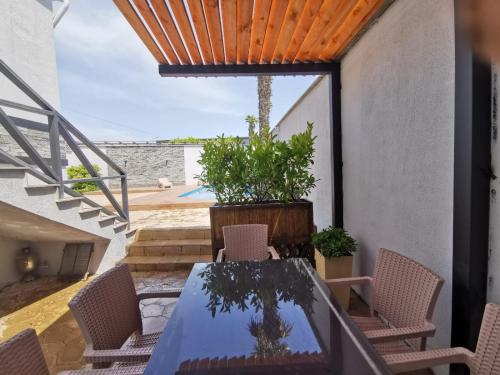 a patio with a table and chairs and a pool at Sunnyside Bilgah villa 2 in Baku